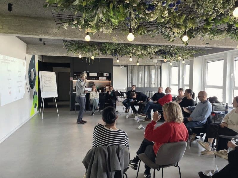 Une session en salle : les participants, assis en cercle, écoutent le formateur.